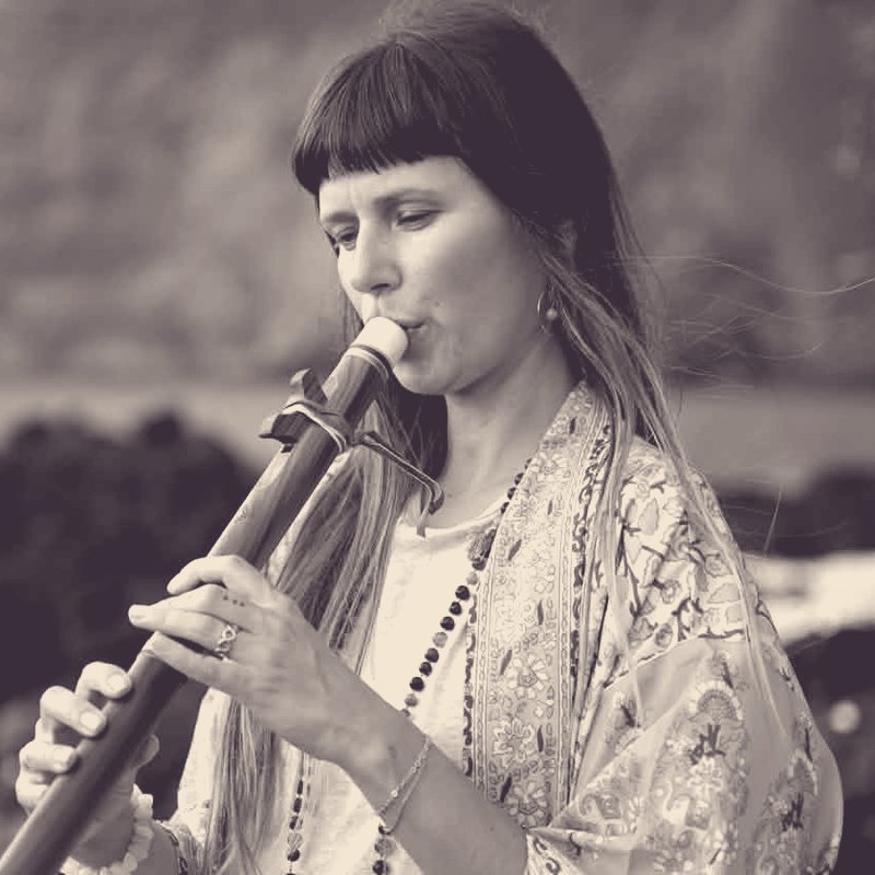 Ola Sangels playing a wooden flute by the ocean
